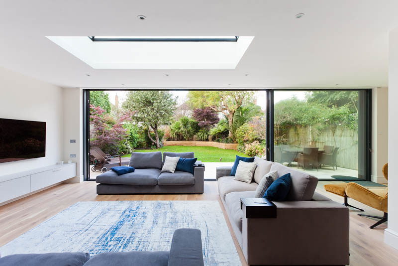 Open-plan house extension kitchen with bespoke cabinetry and rooflight in Ealing